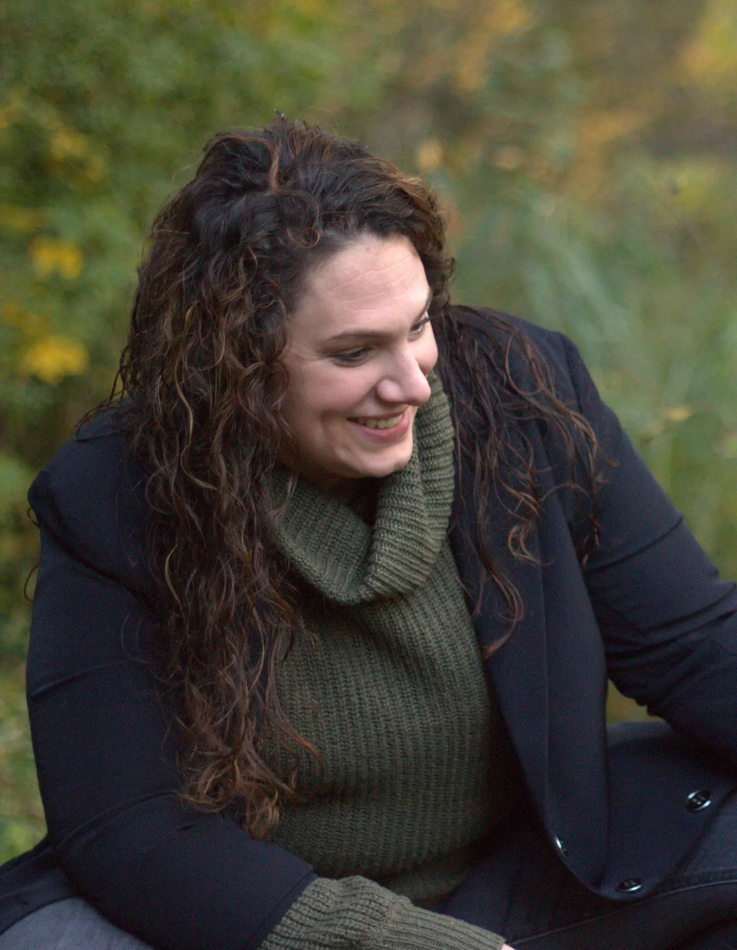 Familiencoach Liza Bruns aus Bremen sitzt mit einem netten Lächeln in der Natur.